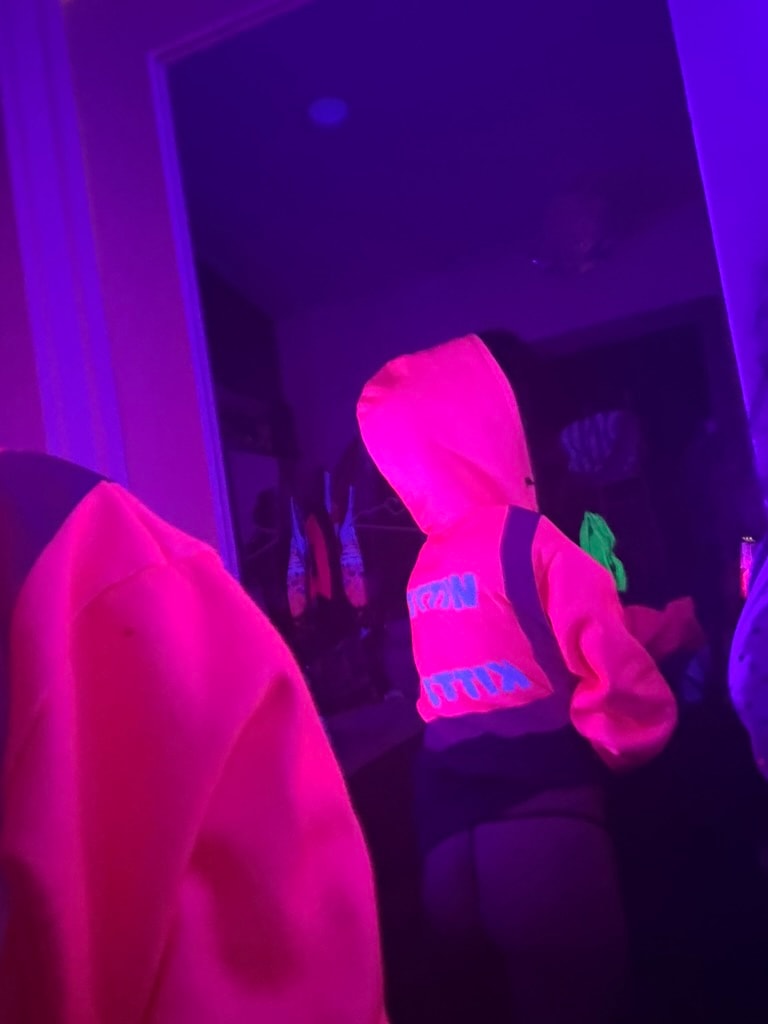 People wearing neon clothing under blacklight